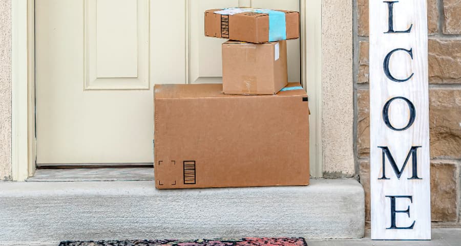 Packages on the doorstep of a home with a welcome sign in Jamestown